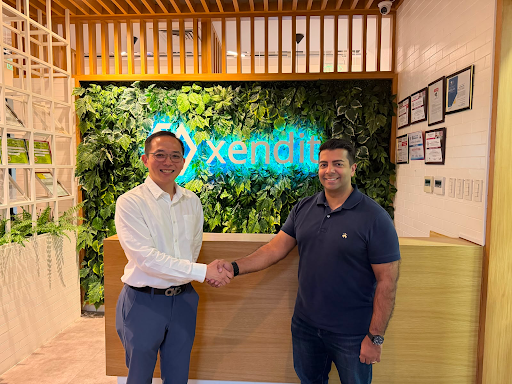 Dragonpay and Xendit representatives shake hands in front of a Xendit sign.